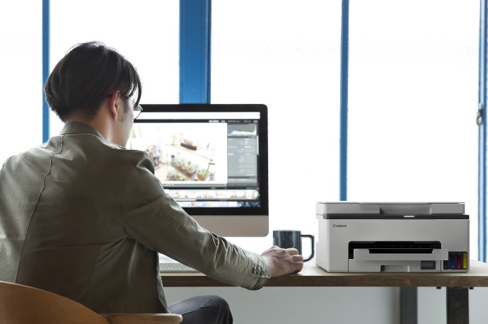A person sitting at a desk using a computer

Description automatically generated